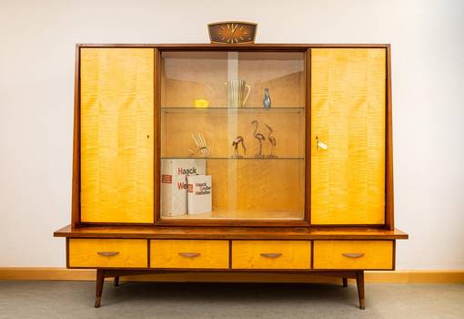 Vitrine aus den Nachkriegsjahren aus Glas und hellem Holz mit typische Objekten wie Haack Atlas