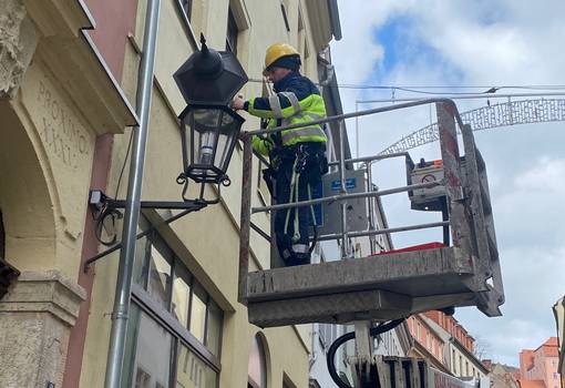 Mann tauscht Lampe auf der Burgstraße aus
