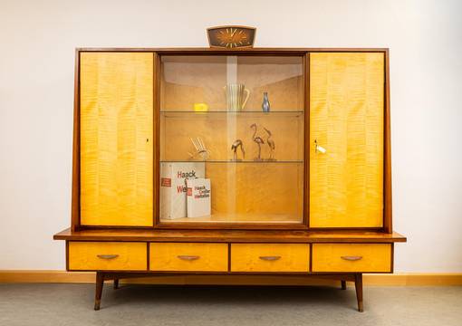 Vitrine aus den Nachkriegsjahren aus Glas und hellem Holz mit typische Objekten wie Haack Atlas